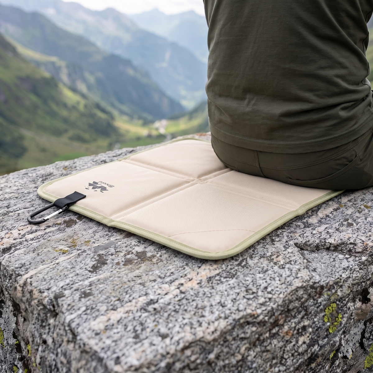 Wanderer sitzt auf dem Bergkraft Sitzkissen auf einem Felsen mit Blick ins Tal